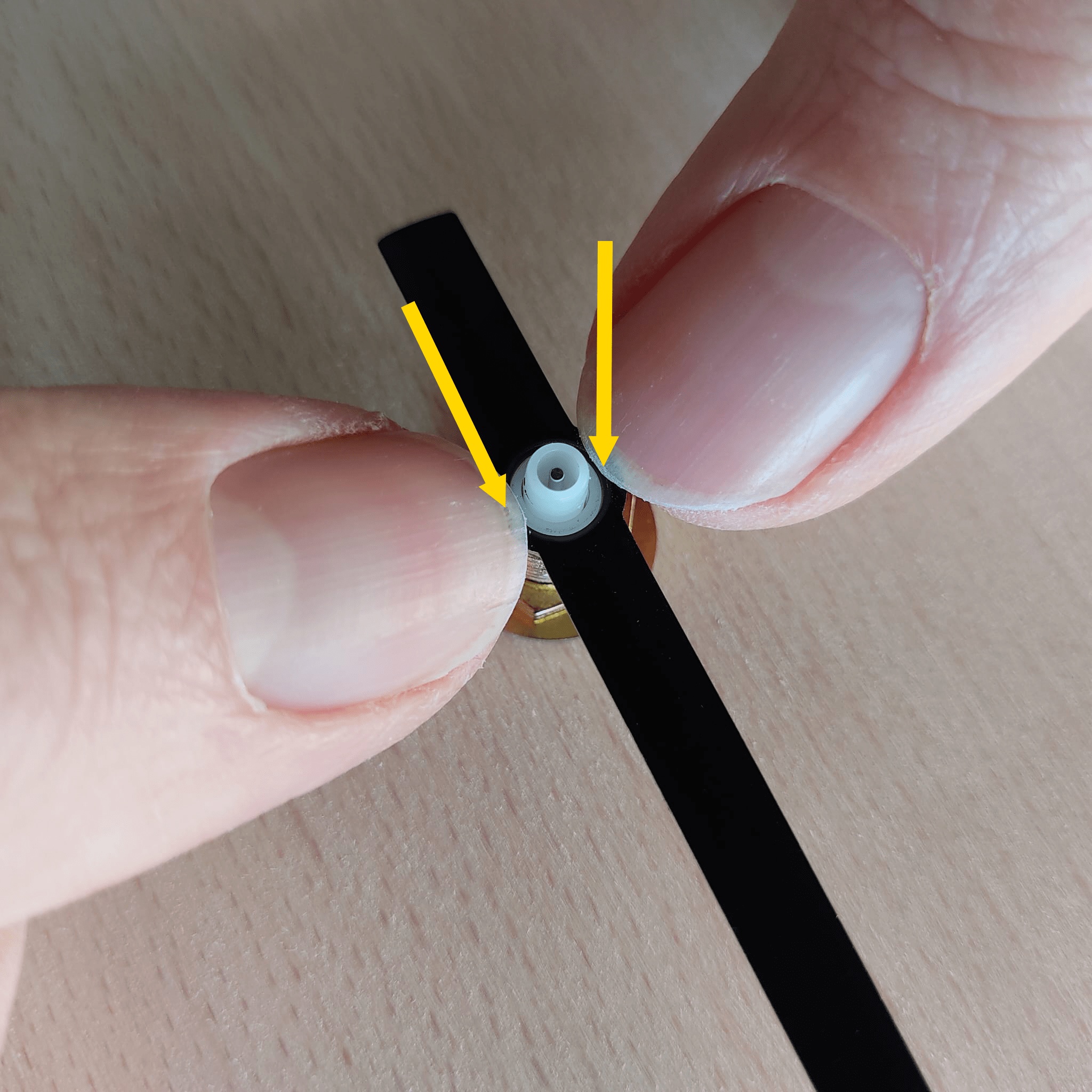 Druk aan beide kanten stevig op de wijzer totdat deze op het witte buisje klikt.