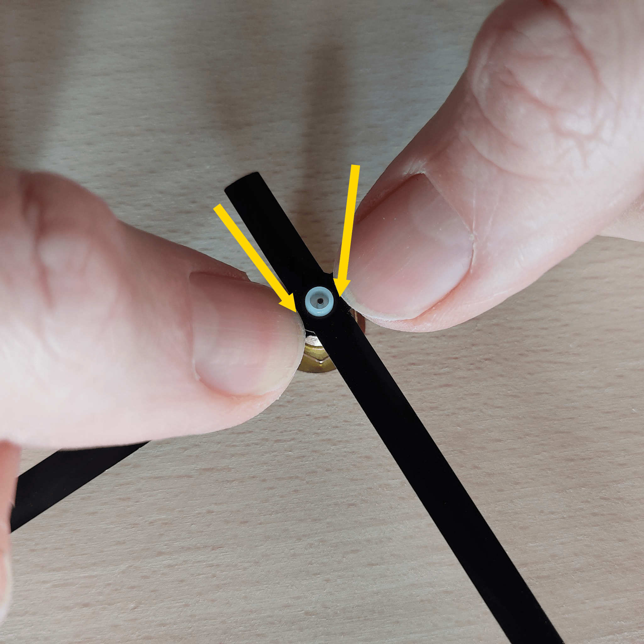 Druk aan beide kanten stevig op de wijzer totdat deze op het witte buisje klikt.