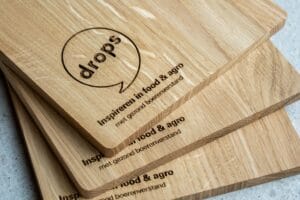 Eikenhouten borrelplank met gegraveerd bedrijfslogo Drops VOF - zakelijk relatiegeschenk Lasergasten